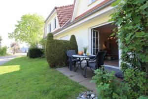 a patio with a table and chairs in a yard at Wohnpark Schmiedestraße App 18 in Wustrow