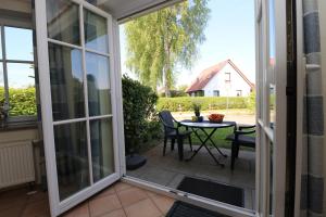 a sliding glass door leading to a patio with a table at Wohnpark Schmiedestraße App 18 in Wustrow