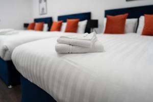 Dos camas con toallas blancas encima. en Water Street by Ustay Aparthotels en Liverpool