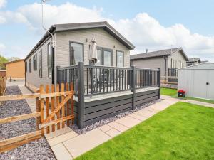 a tiny house with a deck and a fence at 36 Bucklesham Park in Ipswich