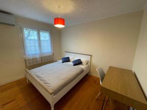 a bedroom with a bed and a table and a window at Green Gables- Old Charm in Vézeronce +14 photos