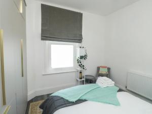 a bedroom with a bed and a window with a window shade at The Annex in Exeter