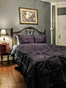 a bedroom with a bed with a purple comforter at Chelsea Pub and Inn in Atlantic City
