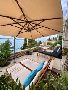 a patio with lounge chairs and an umbrella at Villa Marijam in Hvar