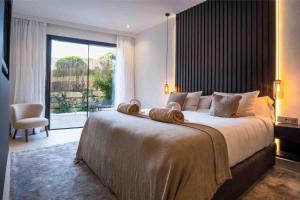 a bedroom with a large bed with a large window at Casa Bodhi Boutique Hotel & Spa in Marbella