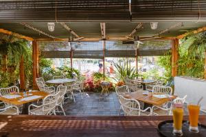 an outdoor patio with tables and chairs and plants at Parque Santiago III Official in Playa de las Americas
