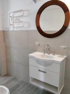 y baño con lavabo blanco y espejo. en Los Zorzales en Villa Carlos Paz