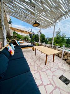 patio con sofá azul y mesa de madera en Villa Marijam, en Hvar