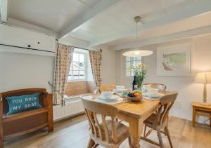 a dining room with a wooden table and chairs at Rose Cottage in Helford