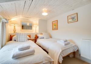 a bedroom with two beds with towels on them at Rose Cottage in Helford