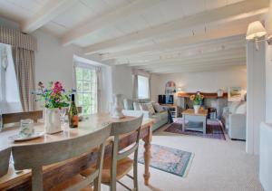 een keuken en een woonkamer met een tafel en stoelen bij Mimosa in Helford