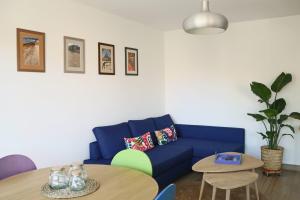 a living room with a blue couch and a table at Uzès centre la TERRASSE des CAPUCINES avec Garage privée in Uzès +30 photos