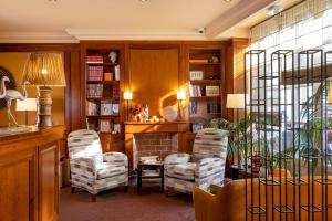 uma sala de estar com duas cadeiras e uma mesa em Hotel Clément em Paris