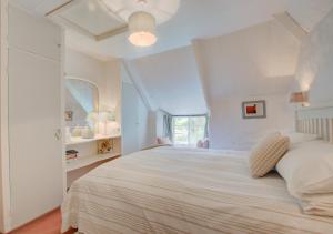 Helford的住宿－Mimosa，卧室配有一张大白色床和窗户