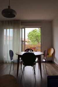 a dining room with a table and chairs and a window at Uzès centre la TERRASSE des CAPUCINES avec Garage privée in Uzès