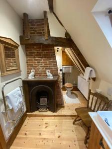 a living room with a brick fireplace in a attic at A newly renovated, cosy escape in the beautiful Shepherd's Cottage in East Dereham
