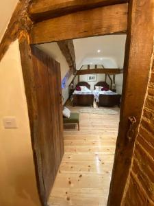 una puerta abierta a un dormitorio con 2 camas en A newly renovated, cosy escape in the beautiful Shepherd's Cottage, en East Dereham