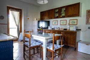 Casa Vacanze Feudi 1165 في Borgo Vodice: مطبخ مع طاولة مع كراسي وقمة كونتر