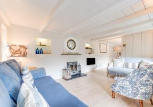 a living room with a blue couch and a fireplace at Well Too in Helford