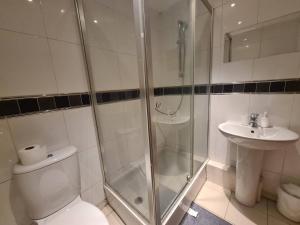 a bathroom with a shower and a toilet and a sink at 2 Bedroom 2 Bath Apartment, sleeps 4, Town Centre in Wolverhampton