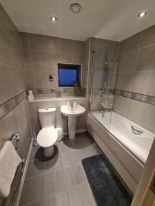 a bathroom with a toilet and a sink and a tub at 2 Bedroom 2 Bath Apartment, sleeps 4, Town Centre in Wolverhampton