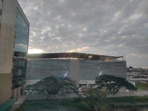 a large glass building with trees in front of it at CON GENERADOR Suite elegante piscina gym parqueo en el norte Gye in Guayaquil