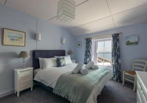 a bedroom with a bed and a window at The Kellan in Mousehole