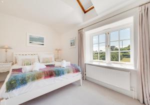 um quarto branco com uma cama e uma janela em Kemyel Mill em Paul