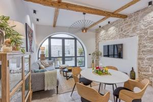 sala de estar con pared de piedra, mesa y sillas en La Pelegrina, en Rovinj