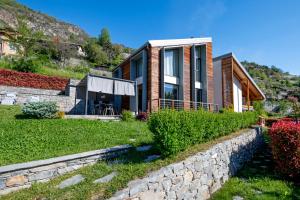 uma casa numa colina com uma parede de pedra em La Maison du Renard, villa con giardino e vista sulle montagne em Aosta