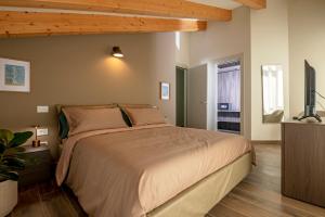um quarto com uma cama grande e uma televisão de ecrã plano em La Maison du Renard, villa con giardino e vista sulle montagne em Aosta