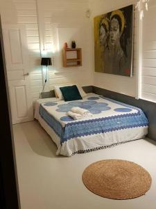 a bedroom with a bed with a rug on the floor at Villa Cocon Bleu , plage à pied ! in Sainte-Luce