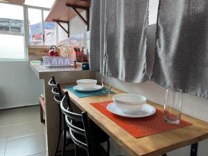 uma cozinha com uma mesa com tigelas e pratos em Tiny apartment in the city rooftop terrace em Baños