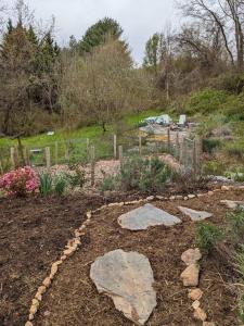 a garden with rocks in the middle of a yard at Victory Garden Cottage 12 min to downtown with fire pit and in Asheville