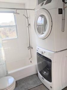 a bathroom with a washing machine and a toilet at Victory Garden Cottage 12 min to downtown with fire pit and in Asheville
