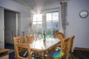 einen Esstisch mit Stühlen und ein Fenster in der Unterkunft Landferienhaus Sonnenblume in Hagen