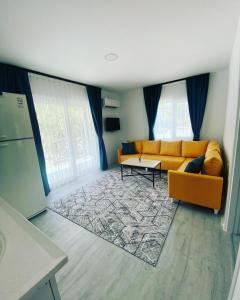 ein Wohnzimmer mit einem Sofa und einem Tisch in der Unterkunft CanBey Apartları in Adrasan