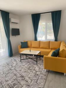a living room with a couch and a table at CanBey Apartları in Adrasan