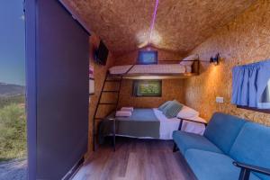 Arrabia Guest Houses Glamping في Raiva: غرفة صغيرة بها سرير وأريكة