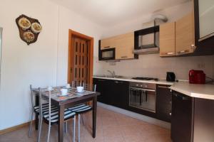 a kitchen with a table and some chairs and a stove at Appartamento Gori in Siena
