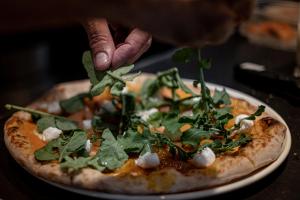 a pizza on a plate on a table at Parque Santiago III Official in Playa de las Americas