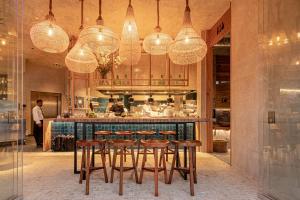 a restaurant with a bar with chairs and lights at Parque Santiago III Official in Playa de las Americas