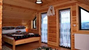a bedroom with a bed in a log cabin at Casa Bozai in Breb