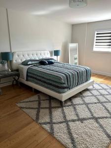 een slaapkamer met een groot bed en een tapijt bij Beautiful townhouse. in Vaughan