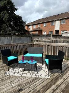 een patio met 4 stoelen, een tafel en een hek bij Beautiful townhouse. in Vaughan