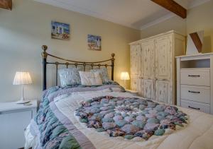 a bedroom with a large bed with a large bedspread at 4 Apartment Pixies Holt in Looe