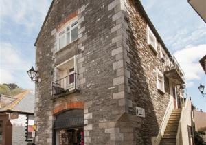 a large brick building with a window and a balcony at 4 Apartment Pixies Holt in Looe