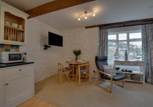 a kitchen and dining room with a table and chairs at 4 Apartment Pixies Holt in Looe