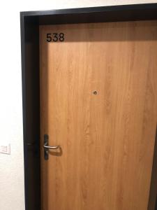 a wooden door with the on it at One bedroom 3pieces entire Modern Appartment close to Airport, CERN, Palexpo, public transport to the center of Geneva in Meyrin