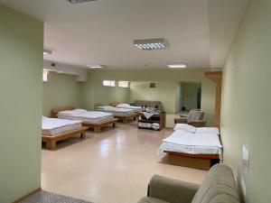 a hospital room with four beds and a couch at Aismares Hostel in Klaipėda